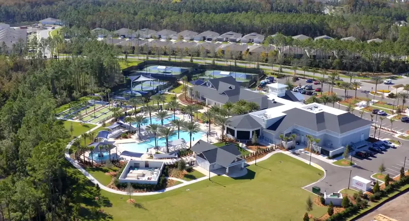 An overhead view of the Canopy Club facilities, including tennis courts and swimming pools, amidst a layout of homes.