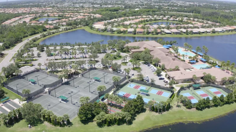 Aerial view of sports courts and lake.