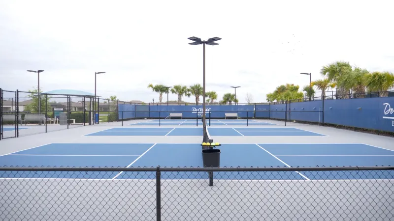 Blue and grey pickleball courts offering an inviting space for Del Webb Bexley players.