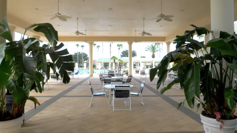 Covered patio and outdoor seating areas adjacent to the pool at Spruce Creek Country Club.