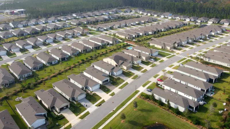 An aerial view of Del Webb eTown with rows of single-family homes, neatly arranged streets, and manicured lawns.