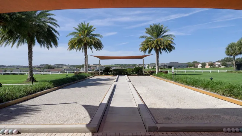 Bocce ball courts covered by sunshades and palms