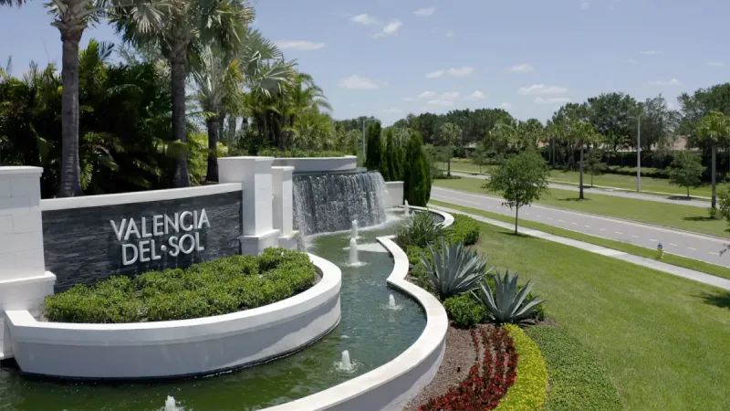 The Valencia del Sol monument sign, accentuated by a fountain and meticulously maintained landscaping.