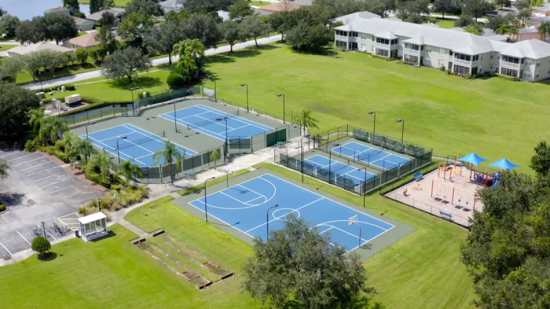 Sports courts surrounded by trees and landscaped lawns.