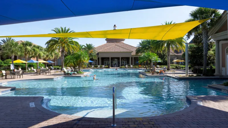 Outdoor pool with sunshades and lounge areas at Trilogy Orlando.
