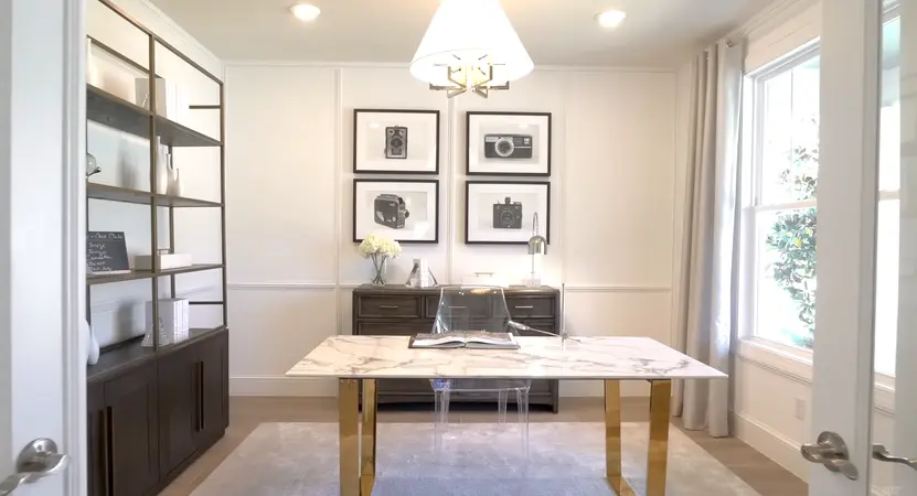 A sophisticated home office featuring a marble desk, a shelving unit, and framed photographs of vintage cameras.
