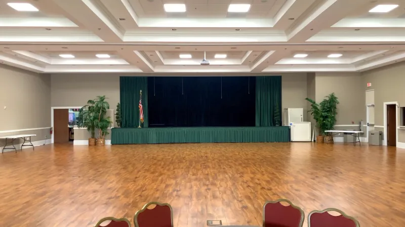 Community ballroom featuring polished wood flooring, beautiful lighting, and plenty of space to accommodate a variety of events and activities.