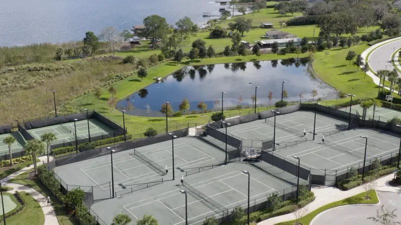 A variety of sports courts looking out over a lake.