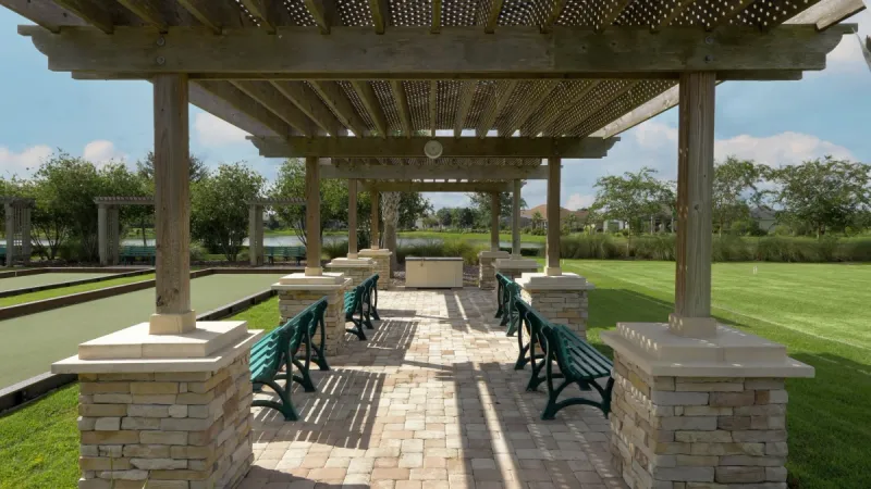 Shaded seating area near sports courts and lake at Lakes of Mount Dora.