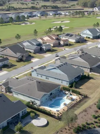 Aerial view of the exteriors of Ocala Preserve homes with a golf fairway in the background.