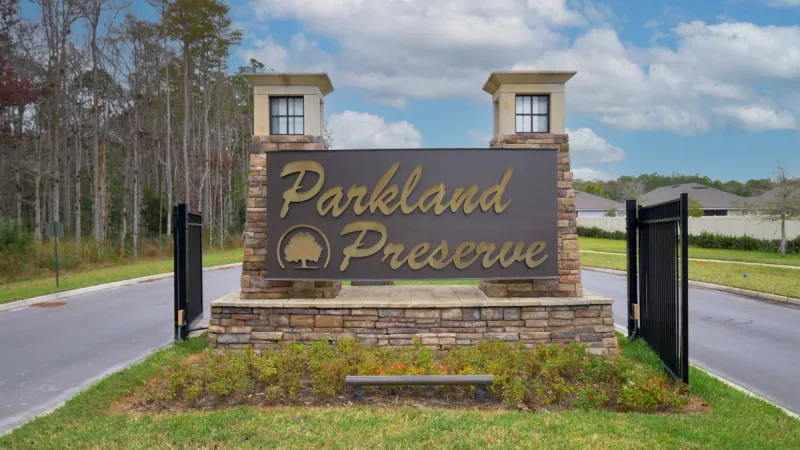 Monument sign at the entrance of Parkland Preserve displaying the name in large letters, located next to a gated entrance.