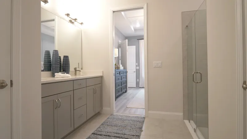 A well-designed and modern bathroom with ample counter space and a shower with a glass door.