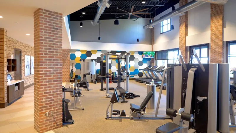 A well-equipped gym area with various types of cardio and weight lifting equipment.