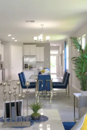 Decorated coffee table in foreground with dining area and kitchen in back.