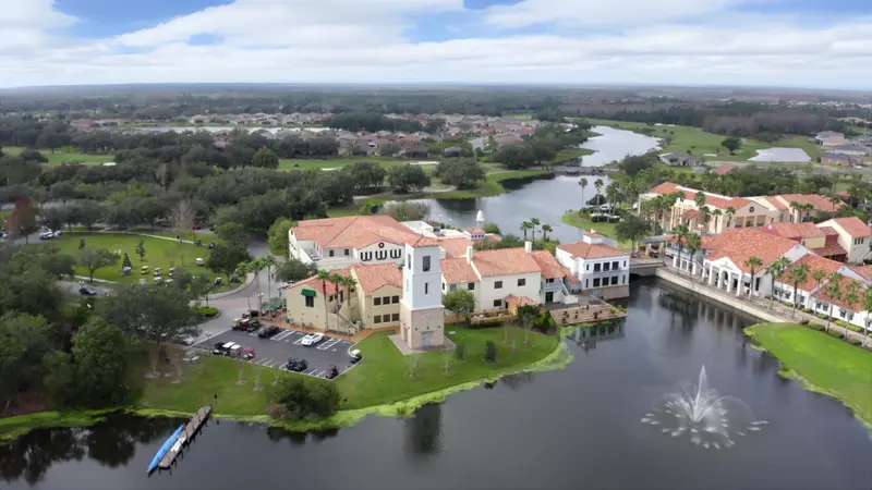 Aerial view of Solivita's clubhouse and surrounding buildings by the lake.