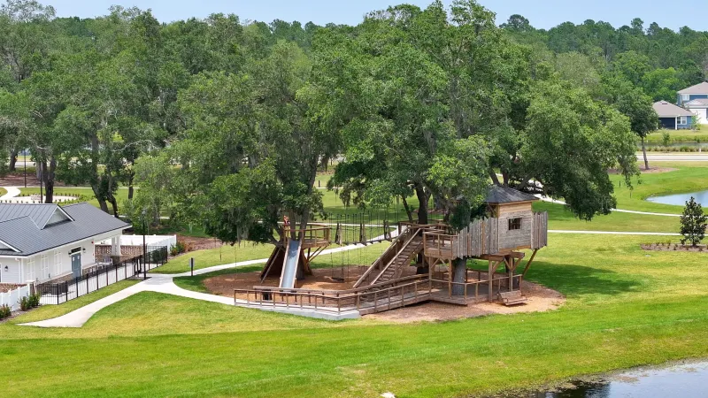 A wooden playground nestled among the trees, providing a natural and fun play environment.