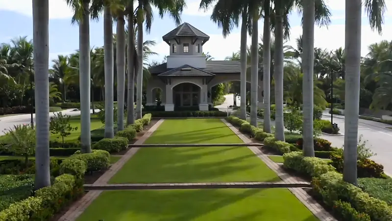 Closer view of the gated entrance to Valencia Cove with palm trees and greenery.