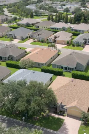 An aerial view of Traditions at Lake Ruby, showcasing the various roofs of houses in a grid-like pattern. The diverse styles and colors of the roofs create a visual interest from above.