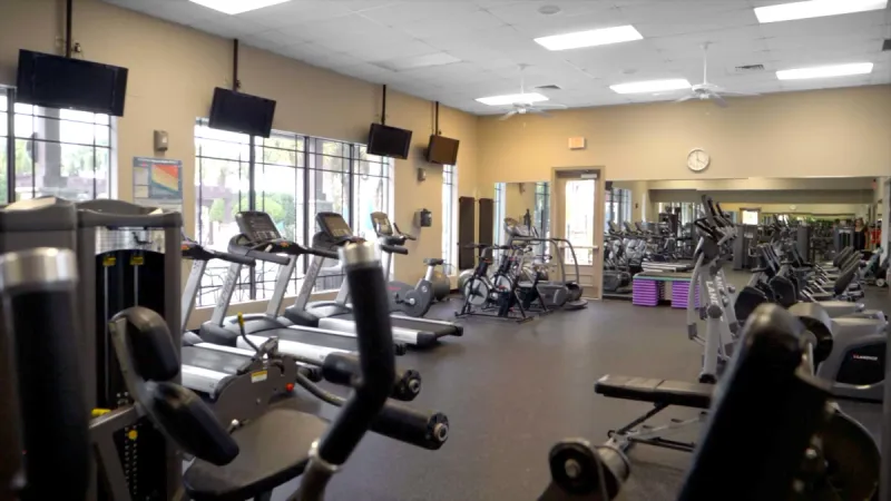 Gym area with treadmills, weight machines and TVs