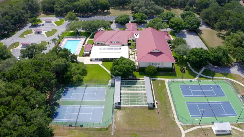 Tennis, bocce, and pickleball courts next to clubhouse and pool area.