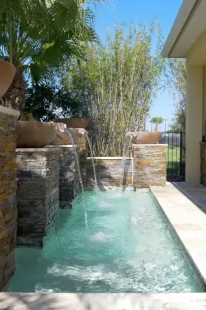 Stone waterfall feature with tropical landscaping.