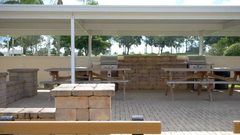 Outdoor grilling area with picnic tables and seating areas.