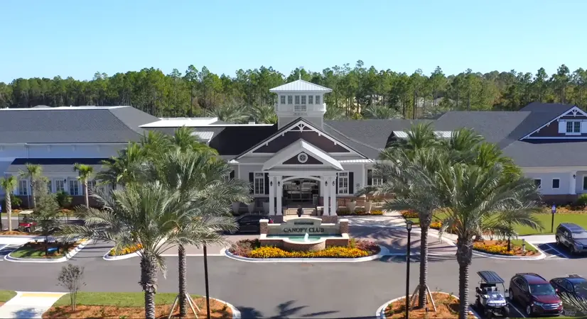 An aerial view of the Canopy Club at Del Webb Nocatee showcasing the grand entrance and palm tree lined driveway.