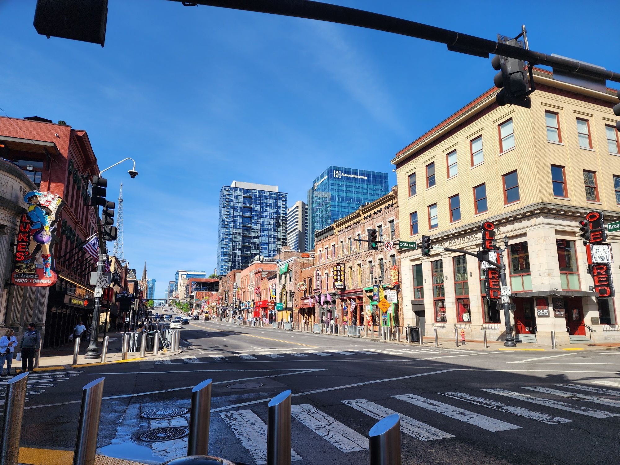 Lower Broadway in downtown Nashville on a sunny day, with brick buildings and a view down the street.