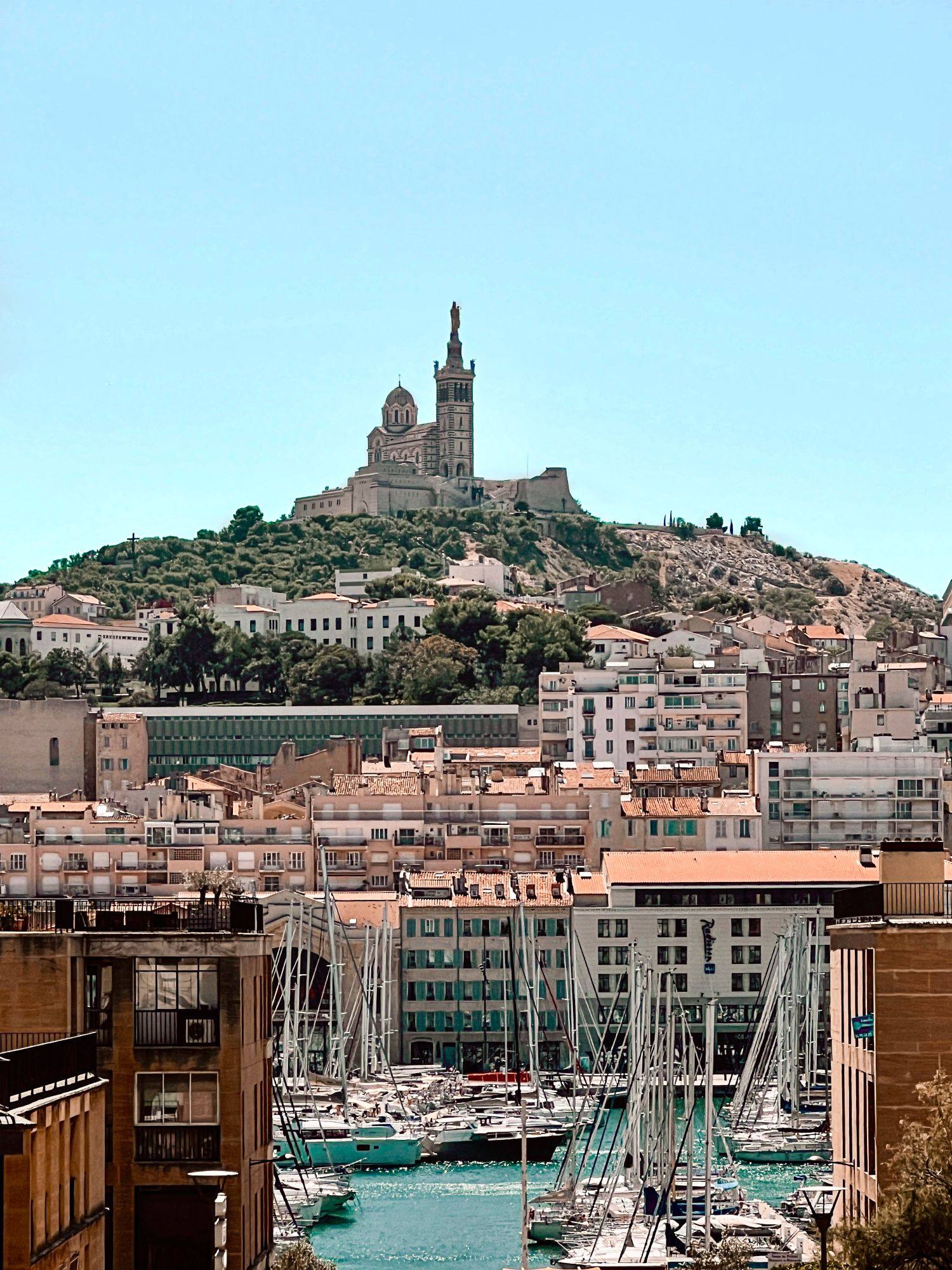 Notre-Dame de la Garde on its hill above the roofs and the marina of Marseille.