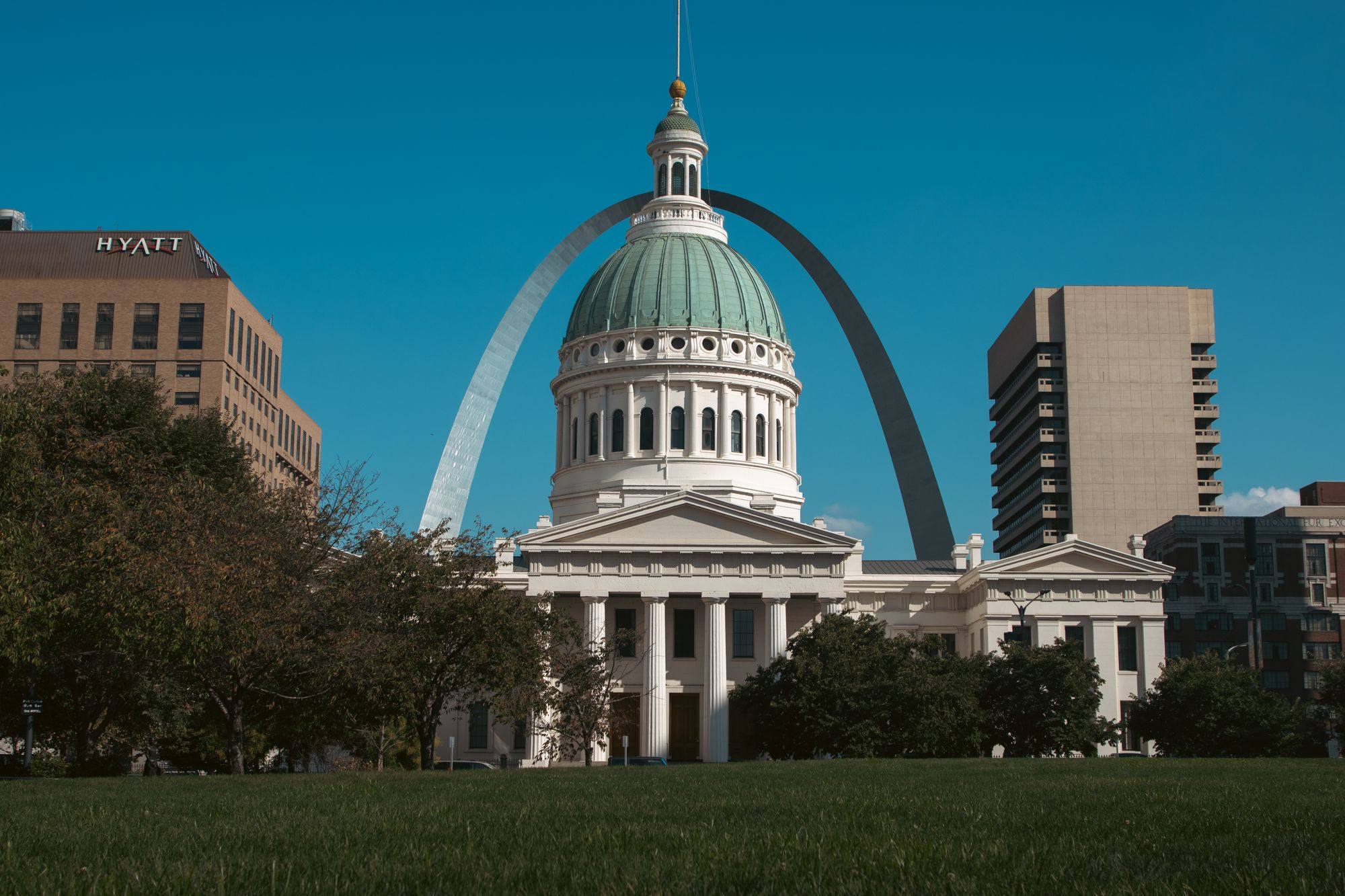 The dome of the Old Courthouse in St. Louis with the Gateway Arch rising behind it.