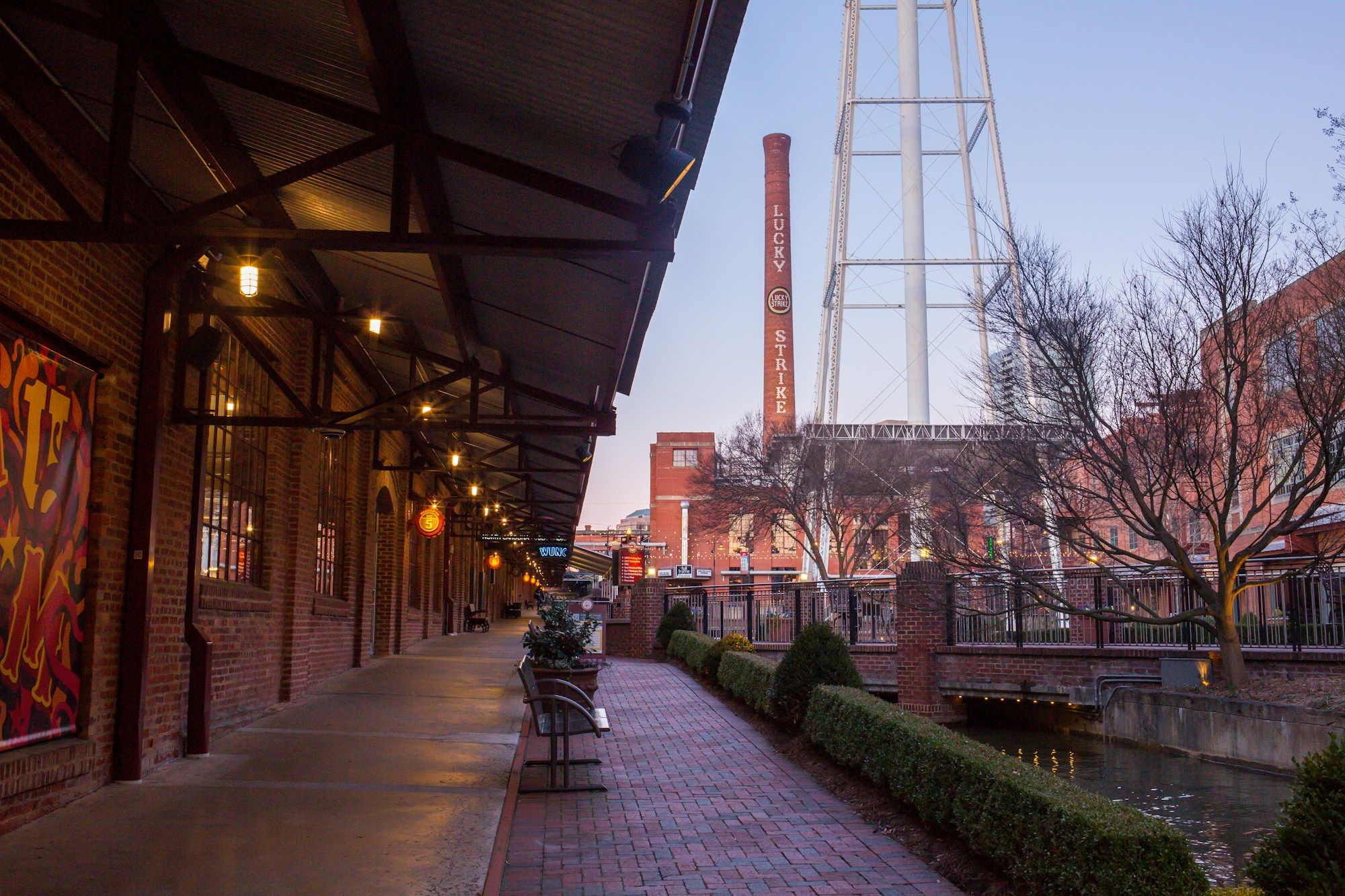 A brick walkway beside the converted tobacco warehouses in Durham, with the water tower behind