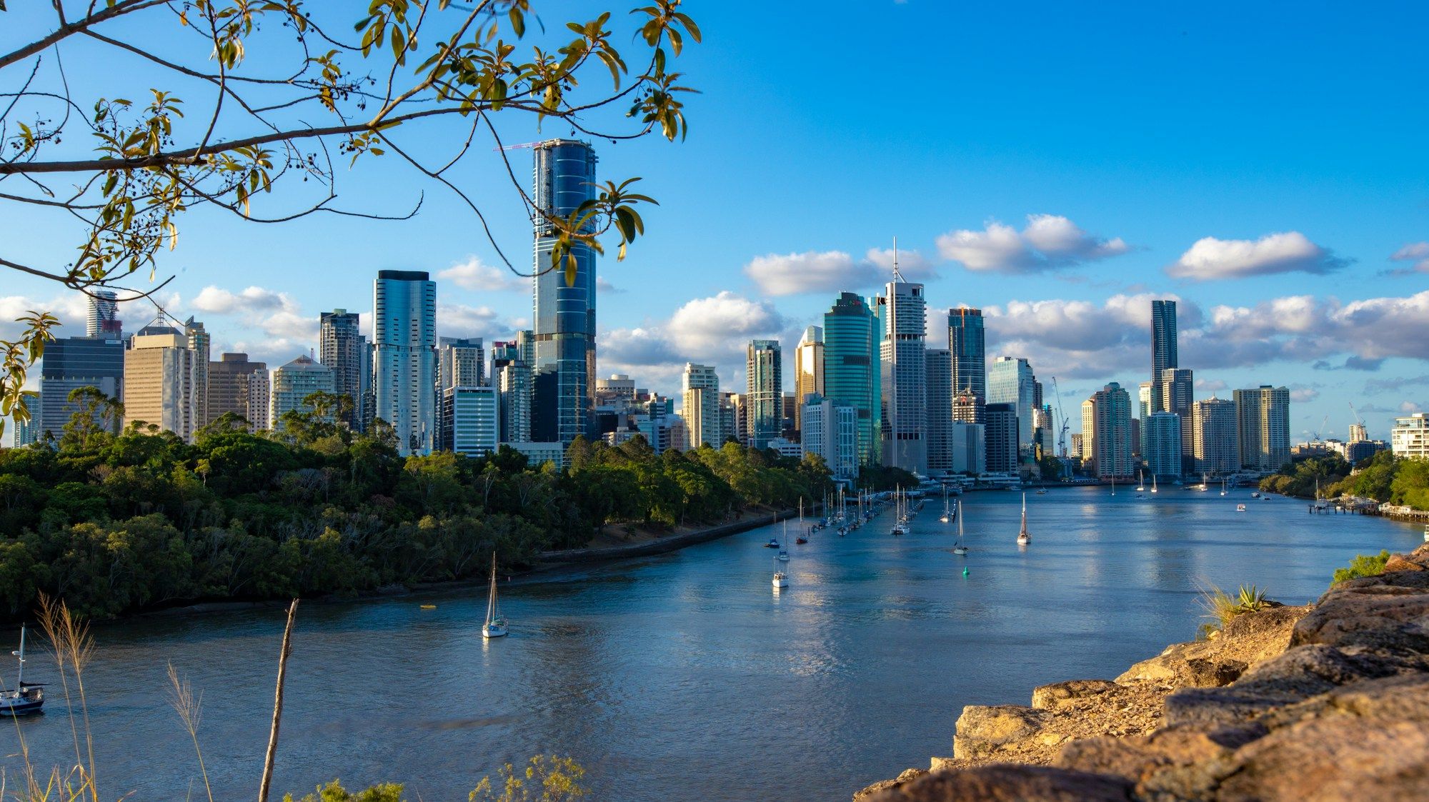 The Brisbane city skyline across the river, seen from the Kangaroo Point Cliffs on a sunny day.