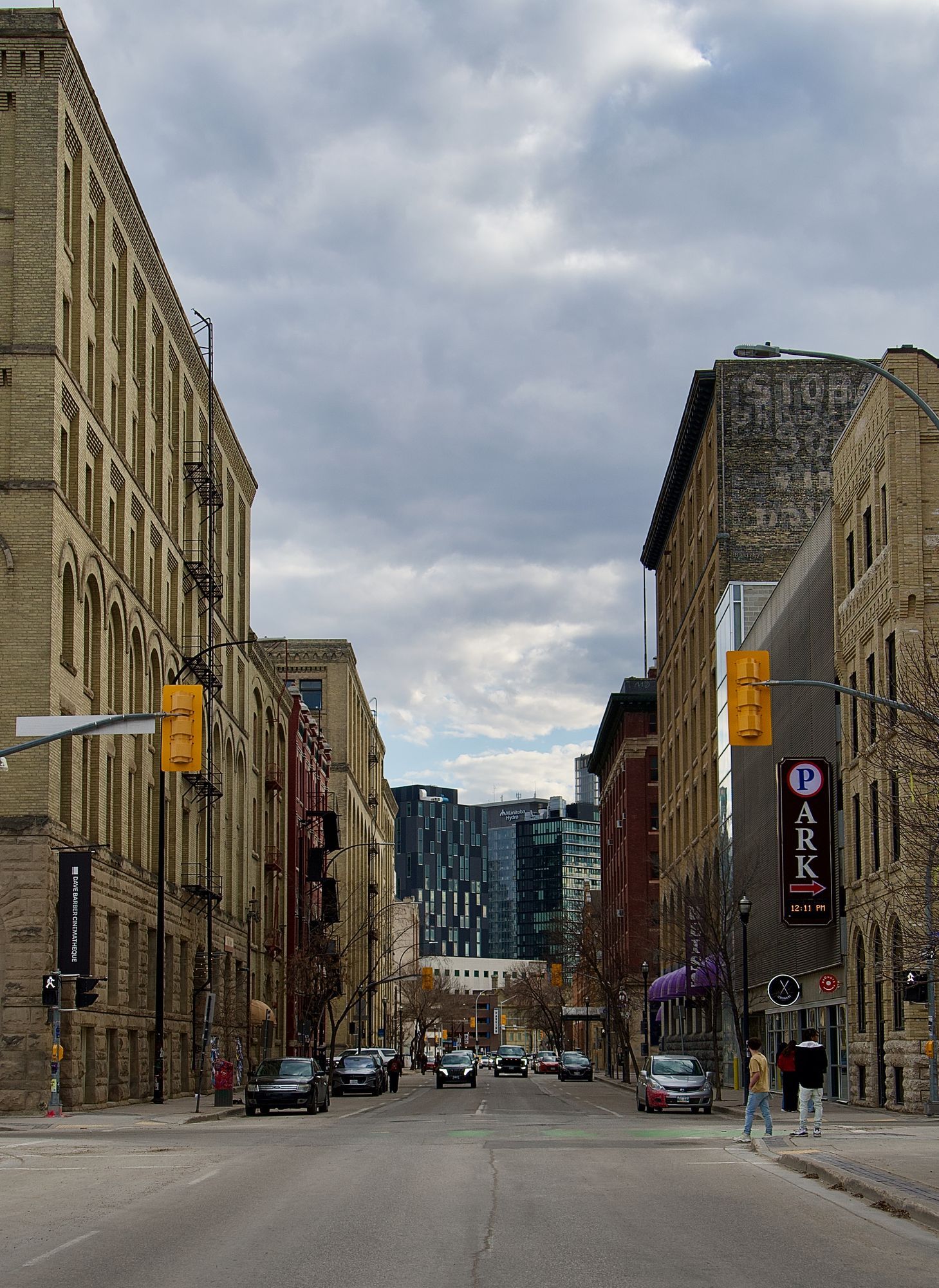 A street of historic brick buildings in downtown Winnipeg, with newer towers at the end of the street.
