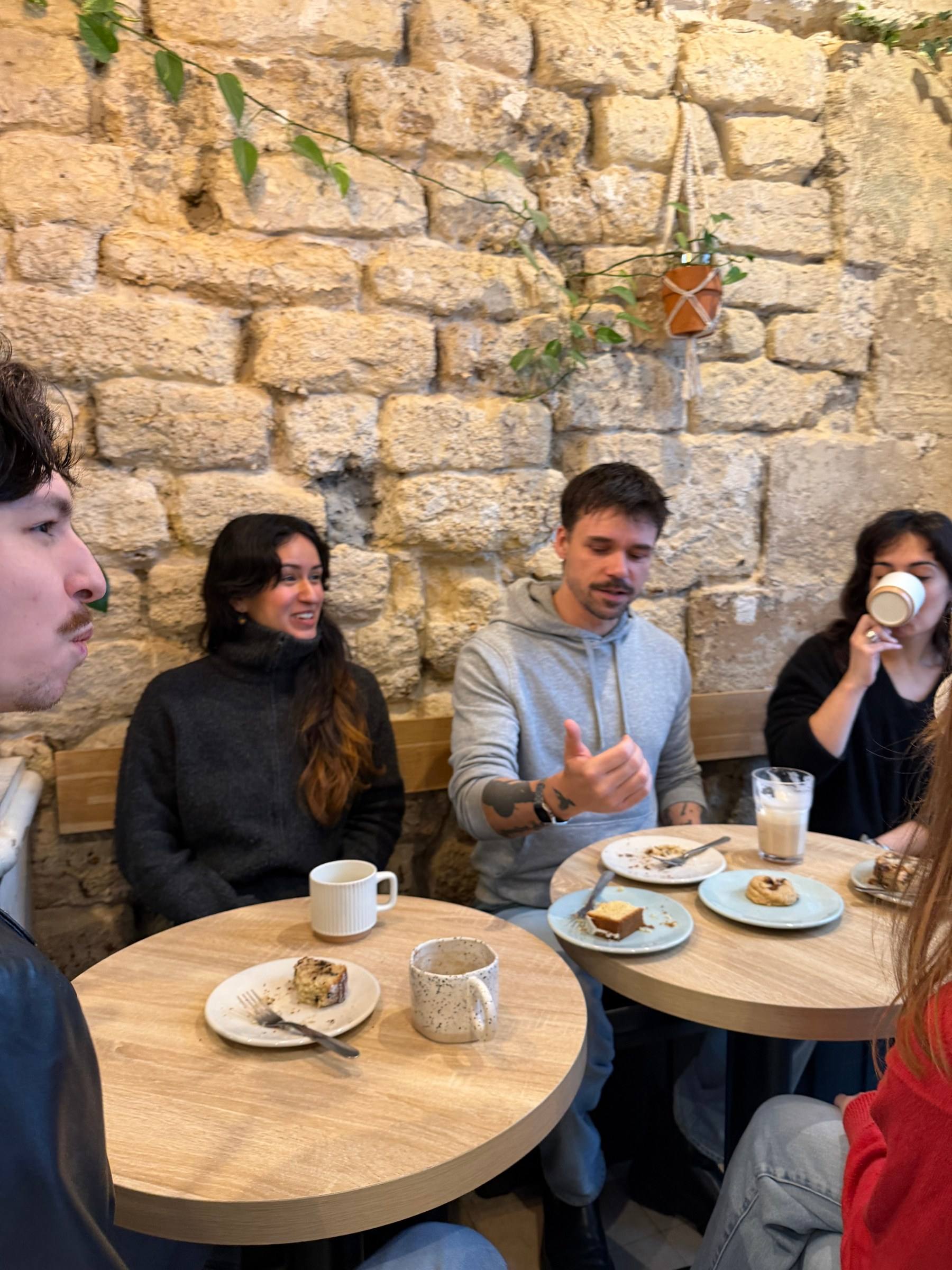 Four people mid-conversation over coffee at a Timeleft coffee