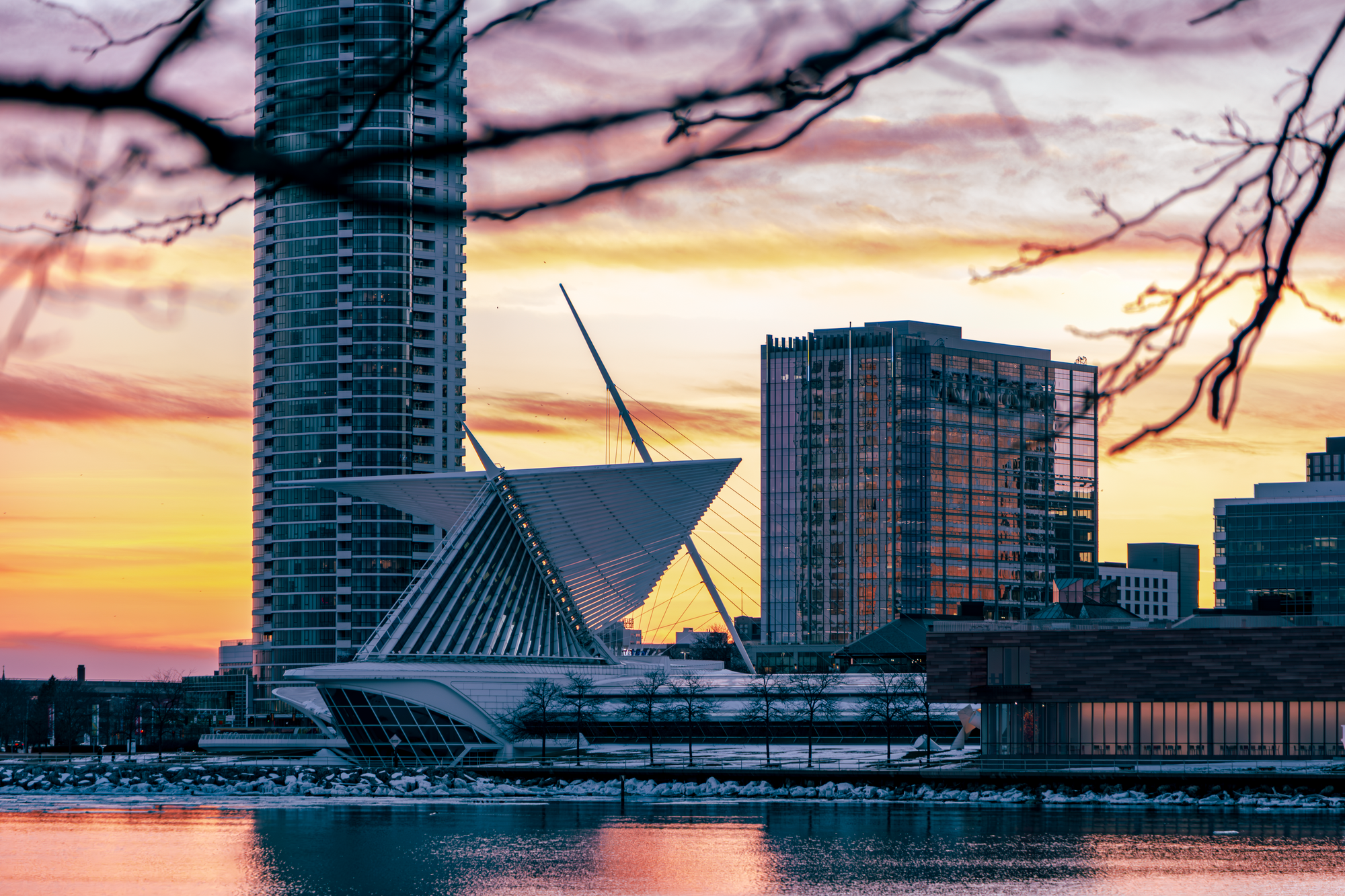 The Milwaukee Art Museum and downtown towers on the lakefront at sunset.