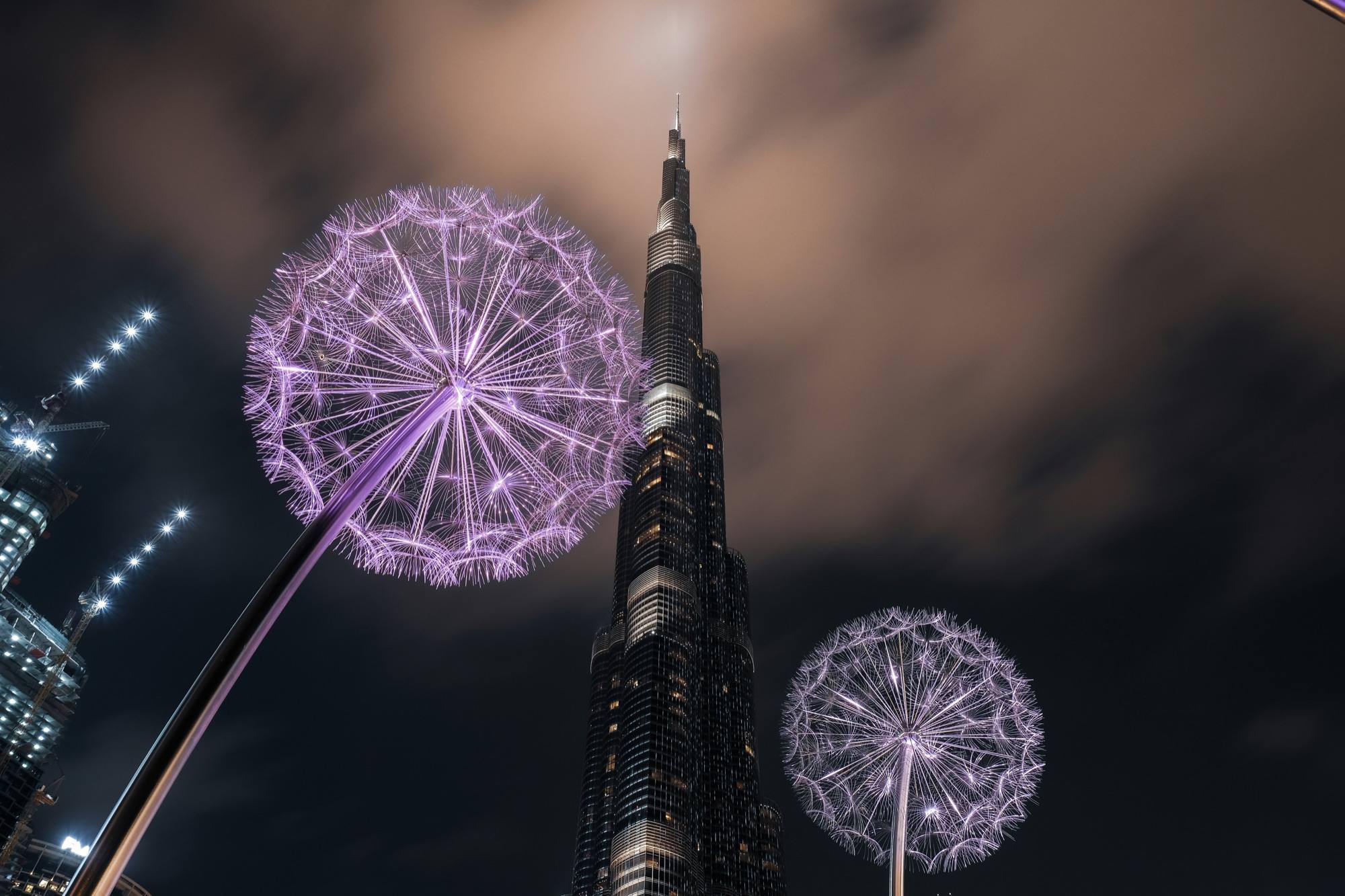 The Burj Khalifa lit up at night under low cloud in Downtown Dubai