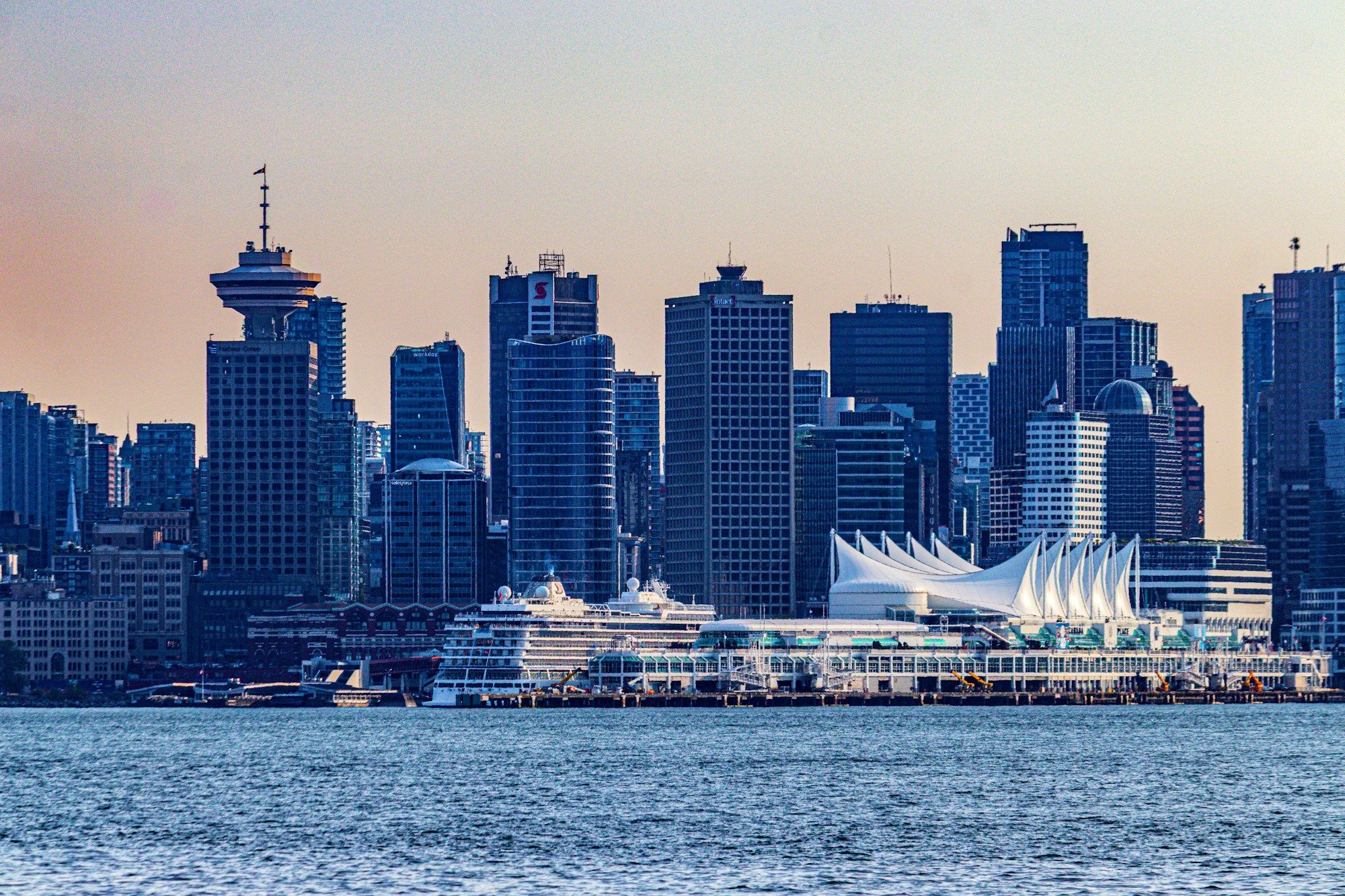 The Vancouver skyline at dusk, with the Harbour Centre tower, Canada Place and a cruise ship on the waterfront.