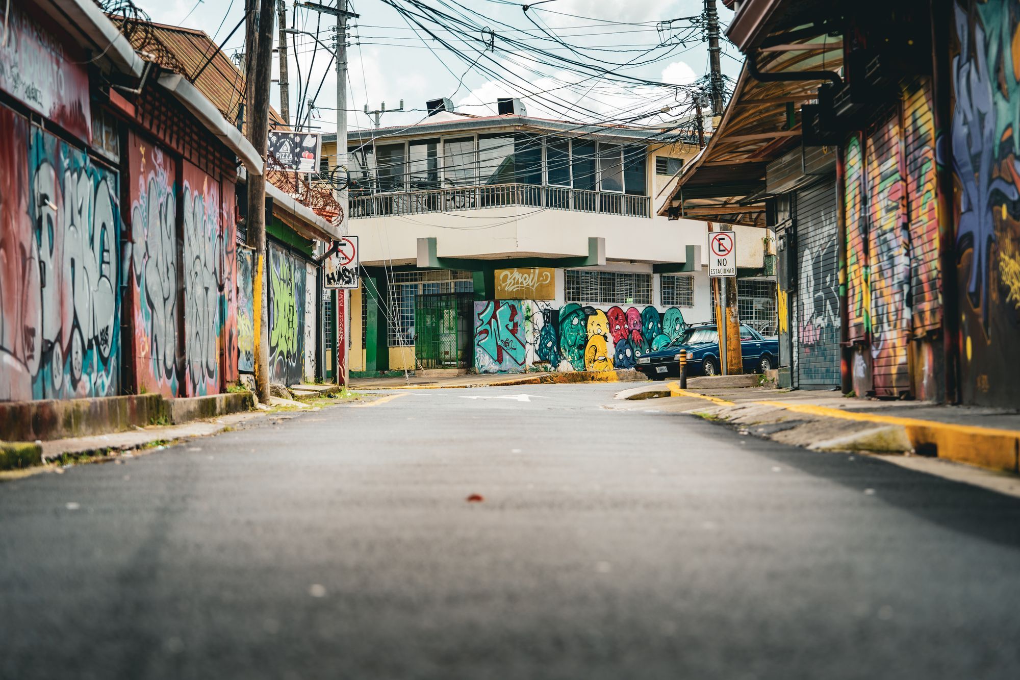 A street lined with graffiti-covered walls in San José, Costa Rica.