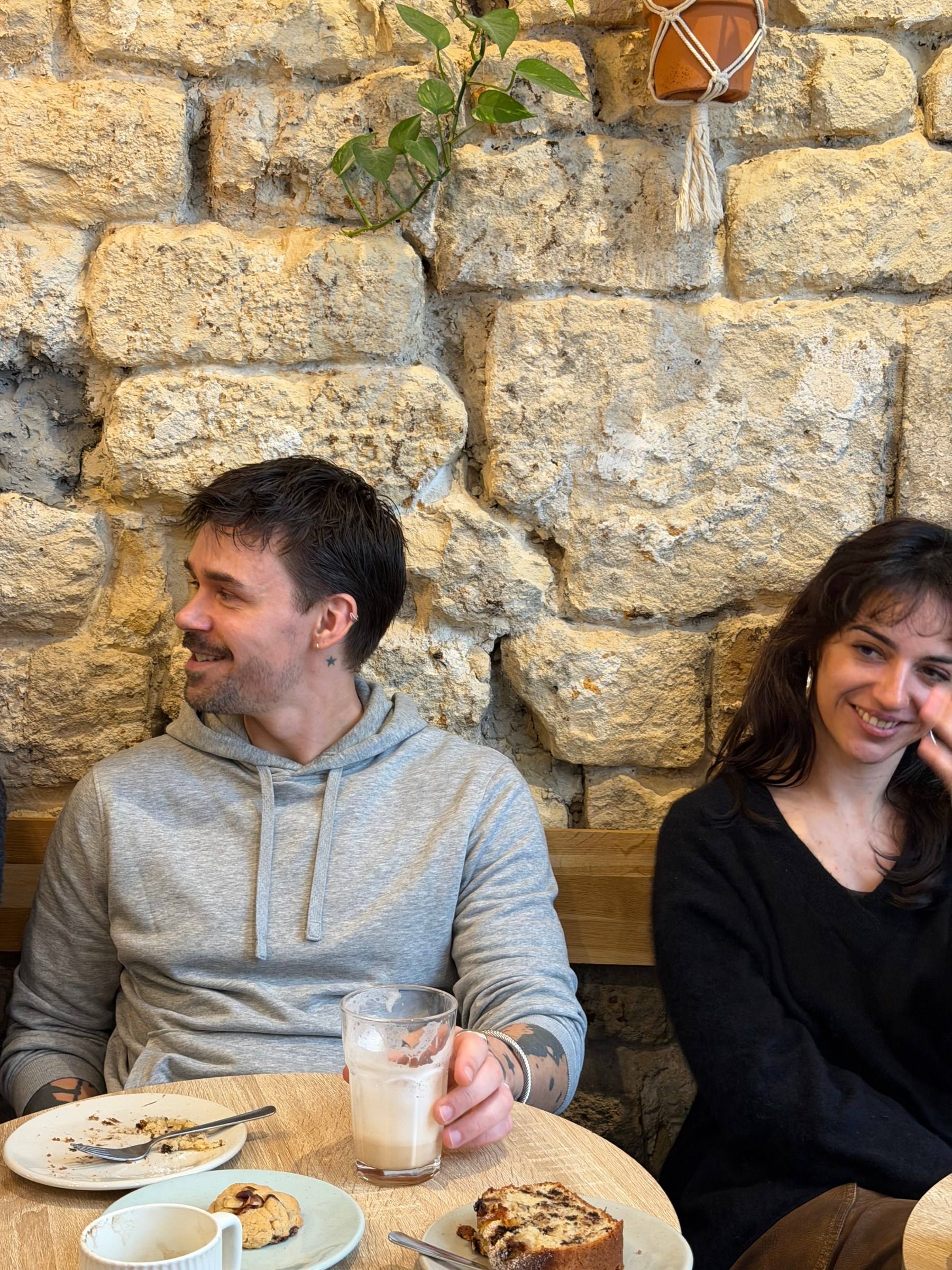 Two people smiling over coffee and cake at a Timeleft coffee