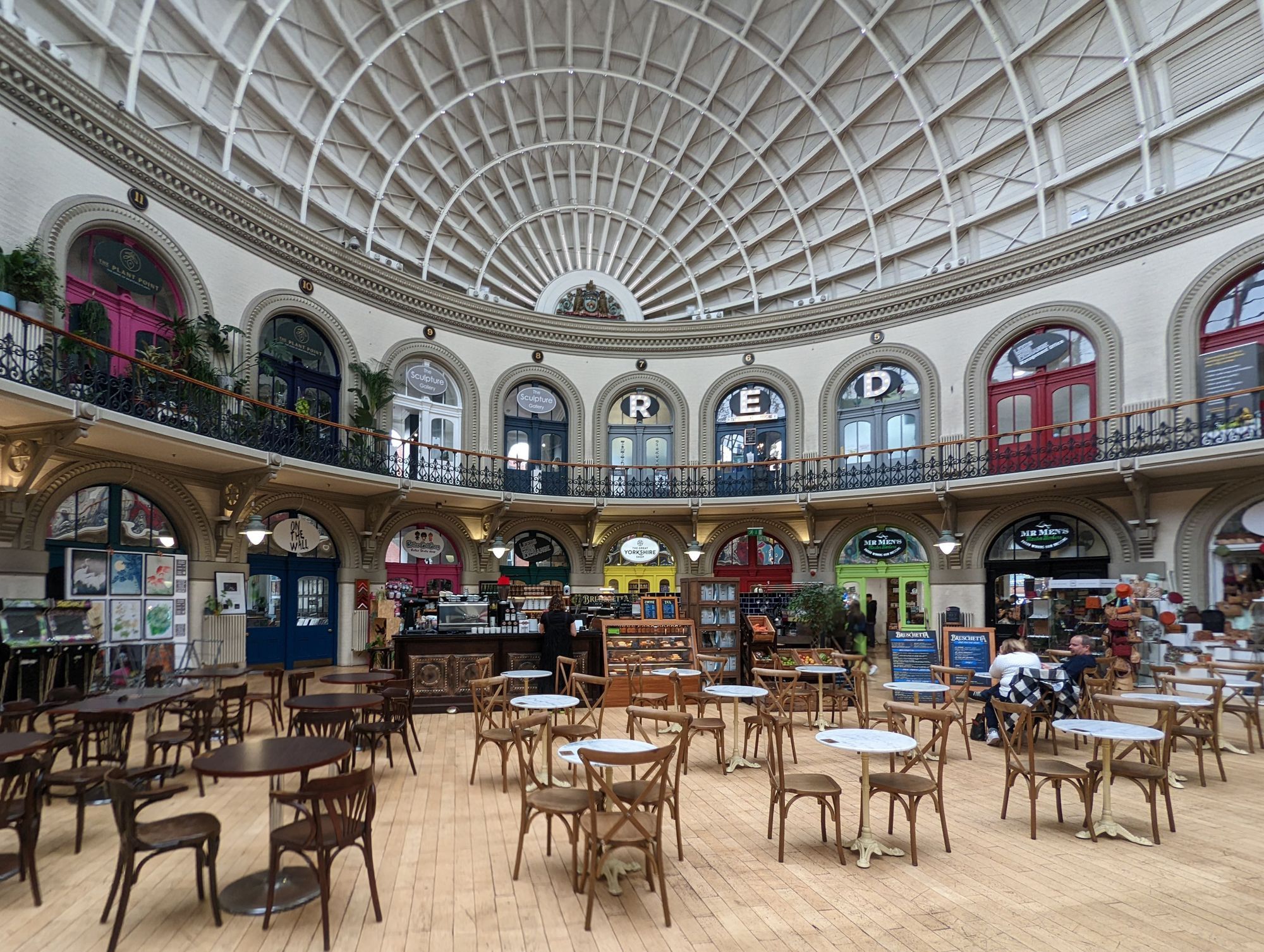 Cafe tables under the domed roof of the Corn Exchange in Leeds.