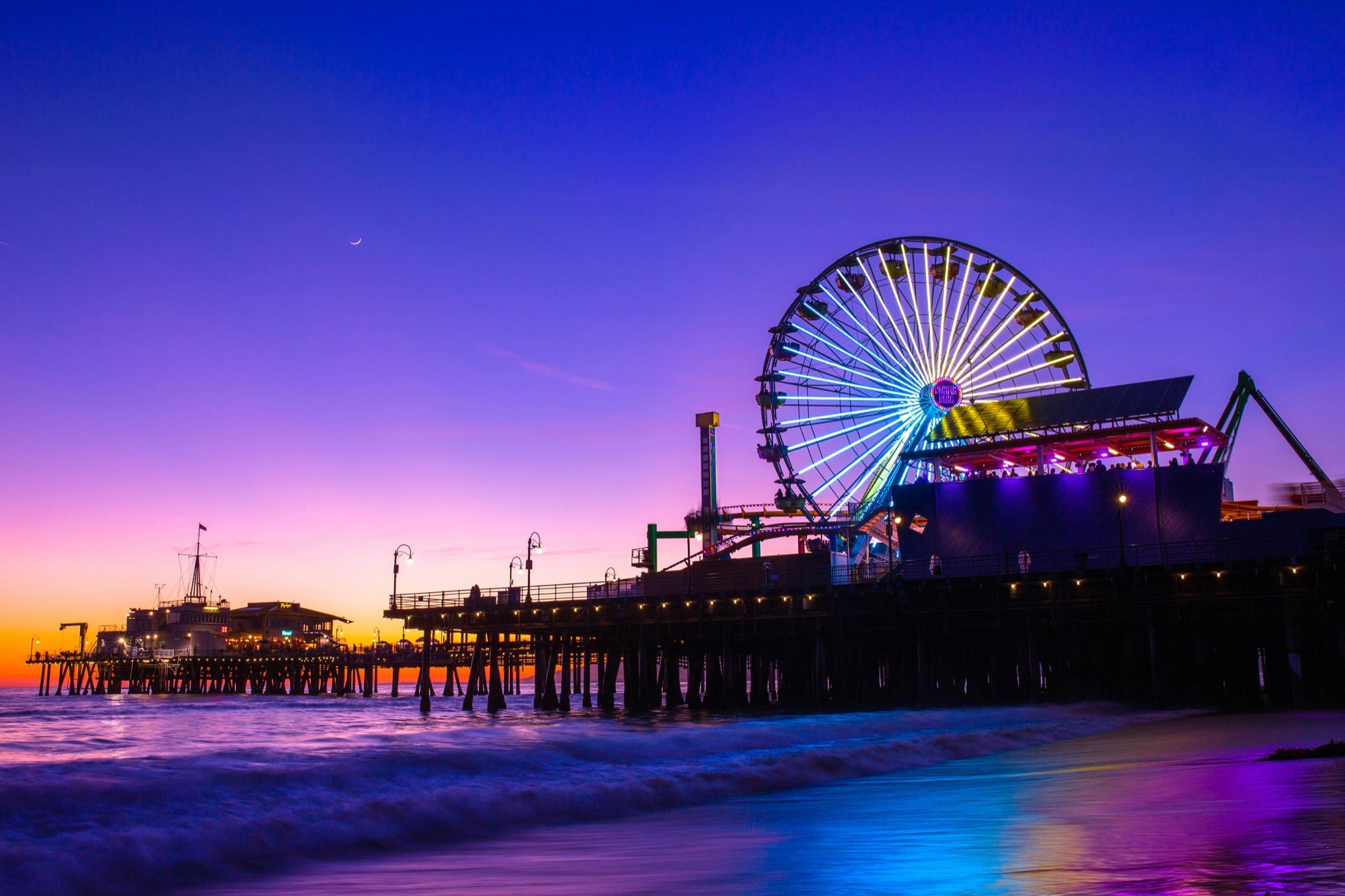 Santa Monica Pier and its Ferris wheel lit up at dusk