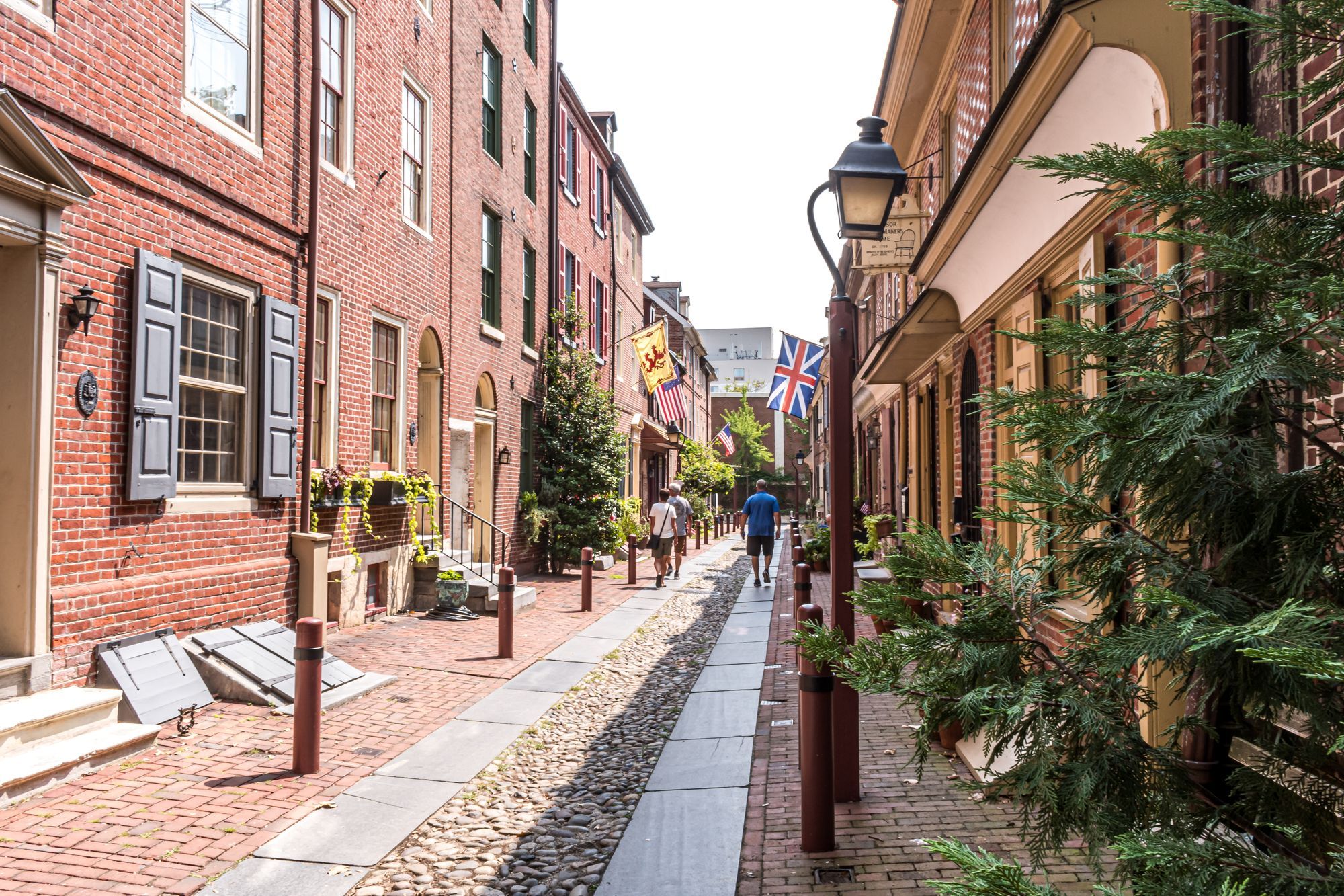Elfreth's Alley in Old City, Philadelphia, a cobbled lane lined with brick houses and flags.