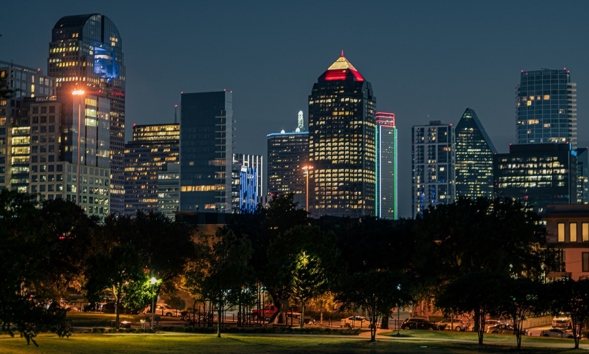 Downtown Dallas towers lit up at night, seen from Griggs Park