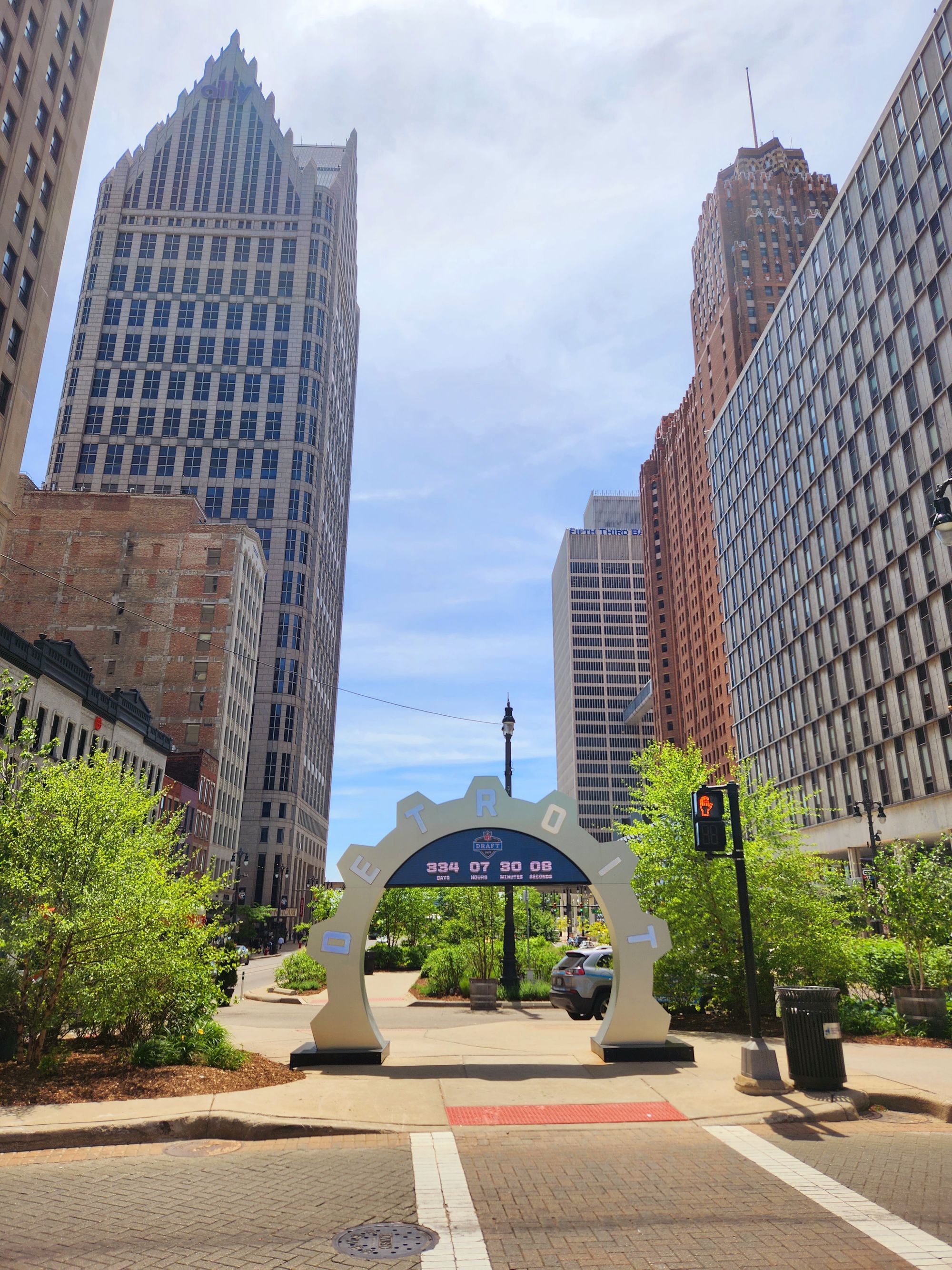 A pedestrian arch on a downtown Detroit street between tall office buildings.