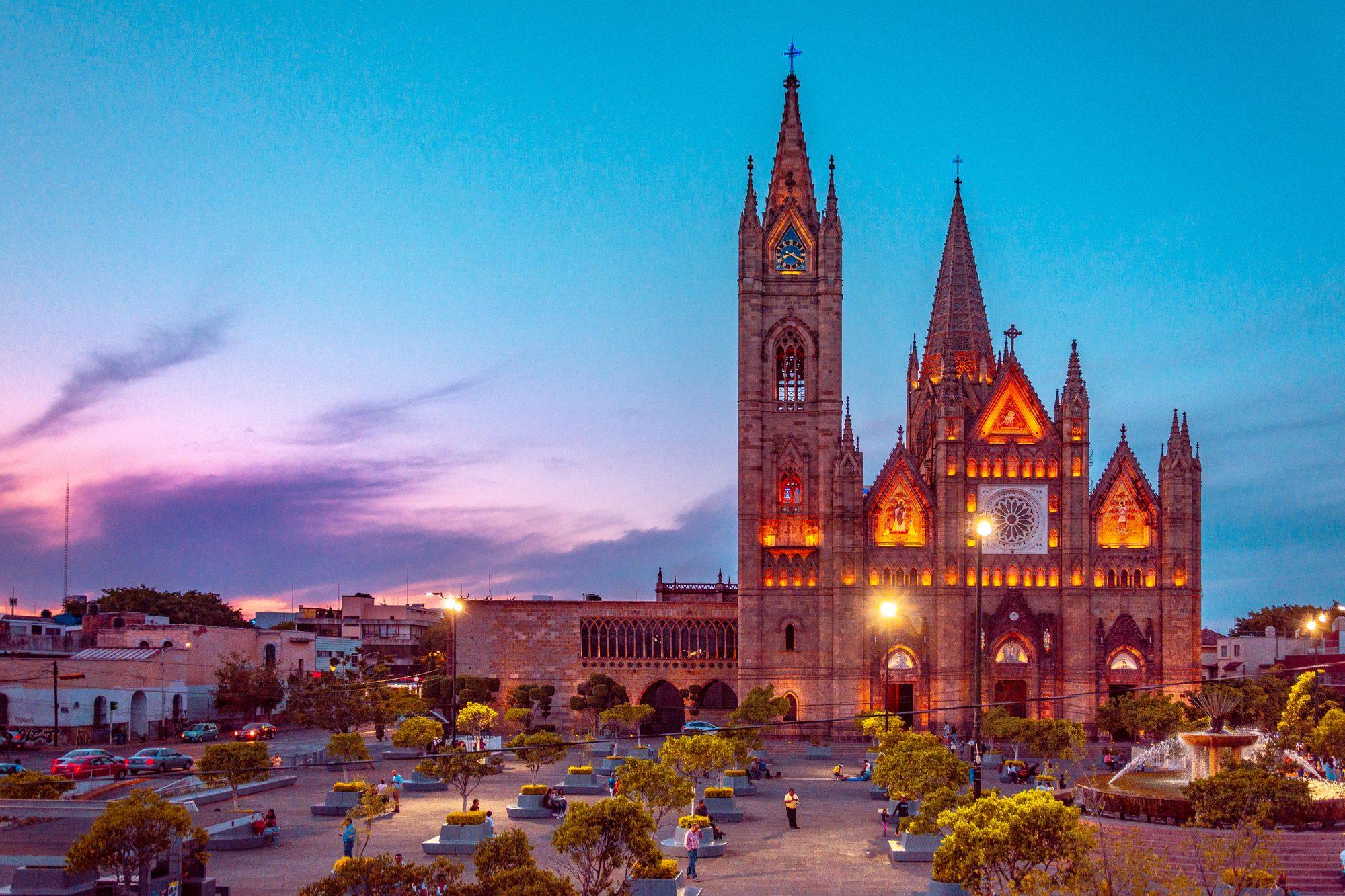 The neo-Gothic Templo Expiatorio lit at dusk above its plaza in Guadalajara.