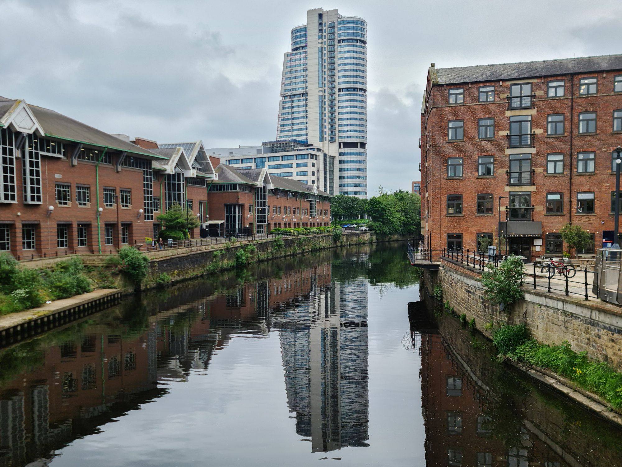 The River Aire in Leeds with brick riverside buildings and the Bridgewater Place tower behind.
