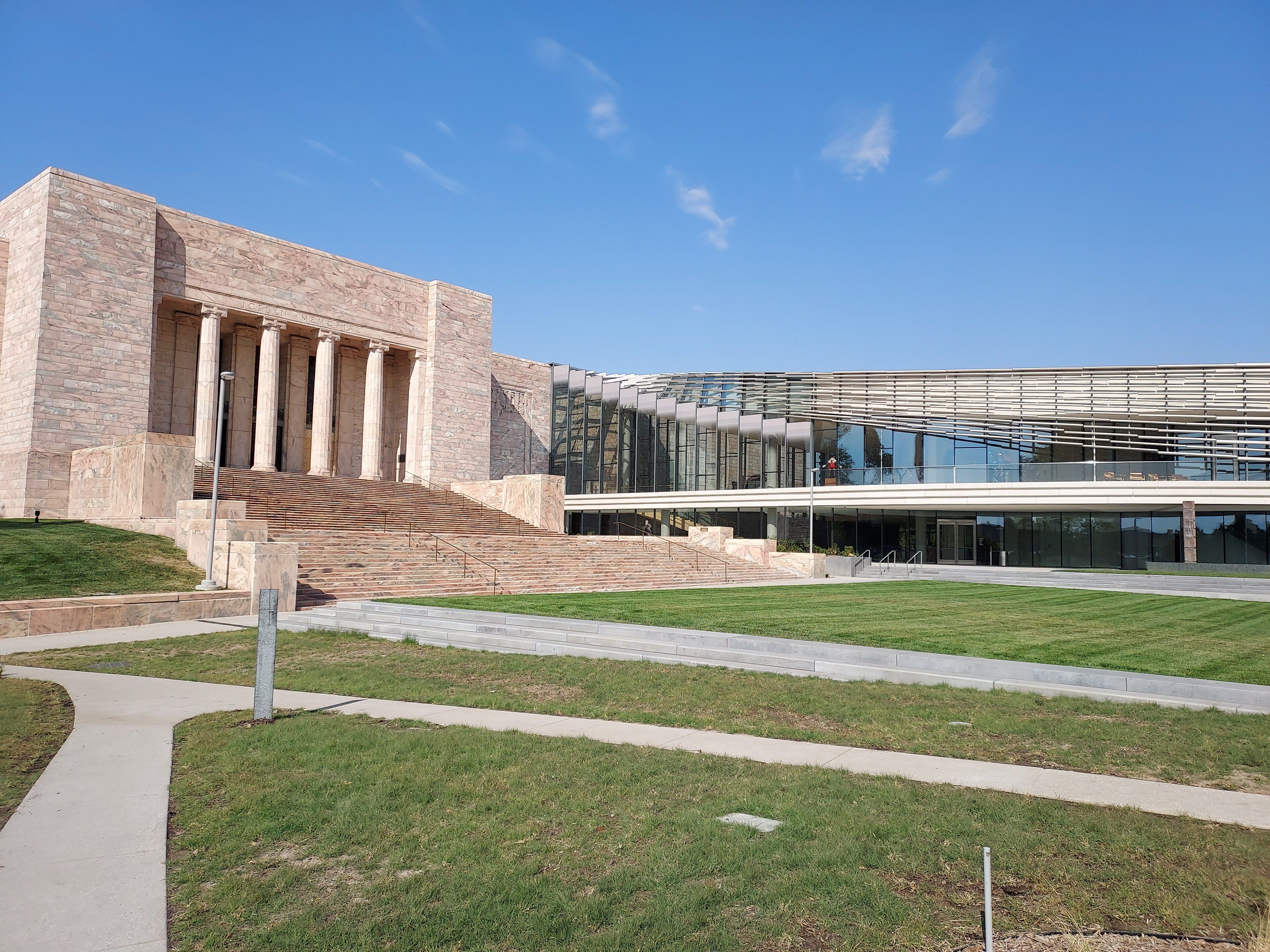 The stone entrance of the Joslyn Art Museum in Omaha, with a lawn in front.