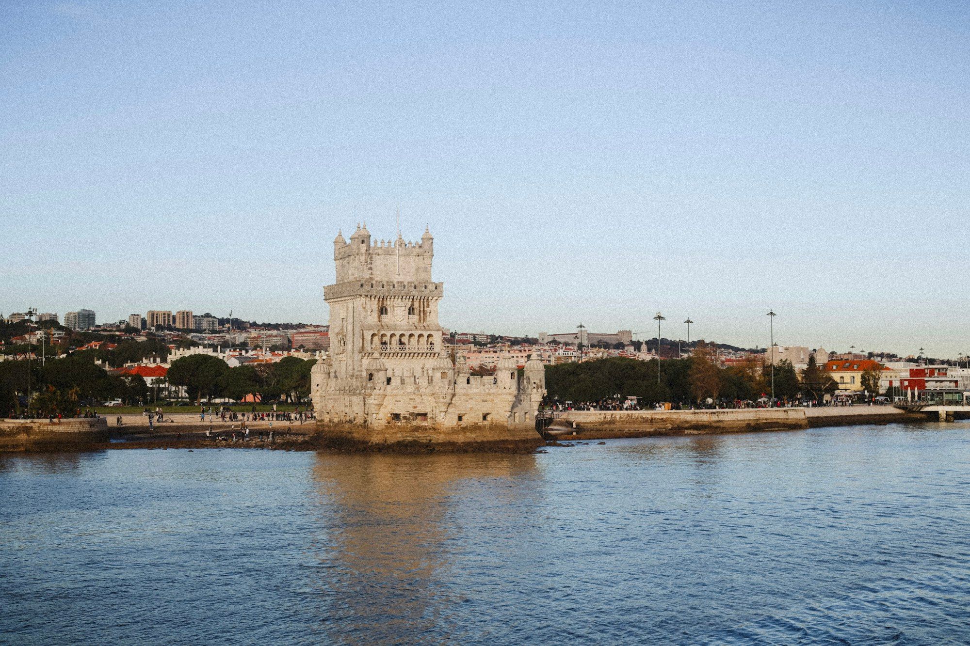 The Belém Tower on the bank of the Tagus in Lisbon, seen across the water in late afternoon light.