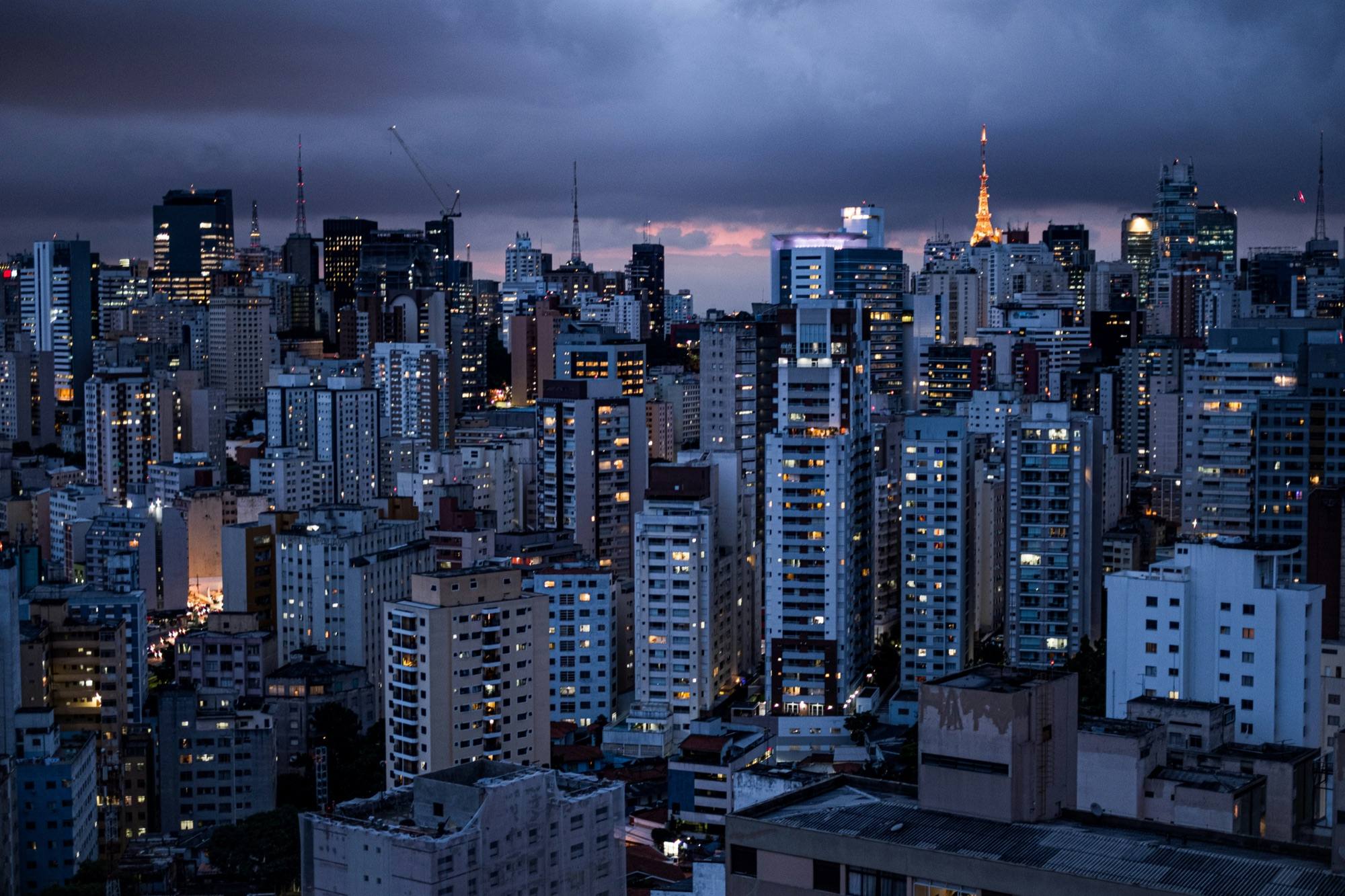 São Paulo’s dense skyline of high-rise buildings under a cloudy evening sky