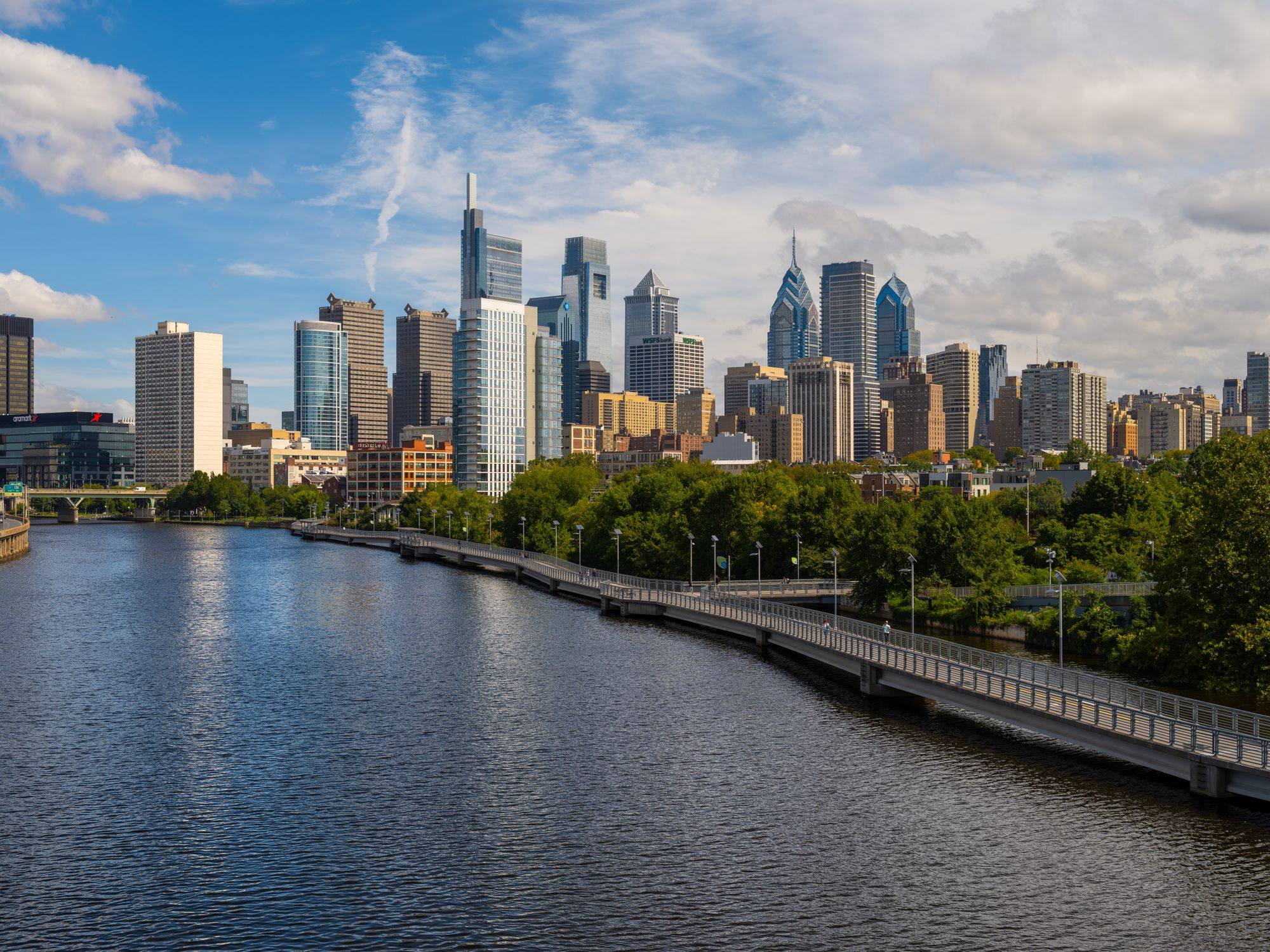 The Philadelphia skyline seen across the Schuylkill River, with the riverside boardwalk on the right.